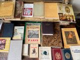 de nombreux livres posés sur une table, avec un miroir en arrière-plan