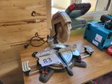 une scie circulaire posée sur une table sur laquelle se trouvent des outils