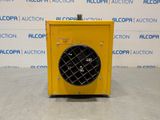 a yellow heater sitting on top of a floor next to a wall