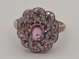 gros plan d'une bague en diamant rose et blanc sur une surface blanche