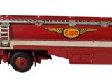 un camion jouet rouge posé sur une surface blanche