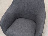 a grey chair that is sitting on the sidewalk
