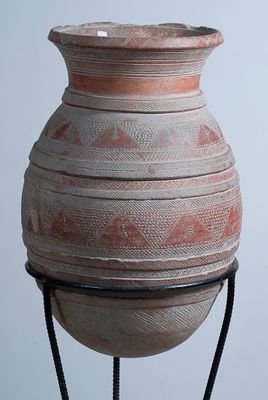 Vase en terre cuite à motifs géométriques, sur socle.