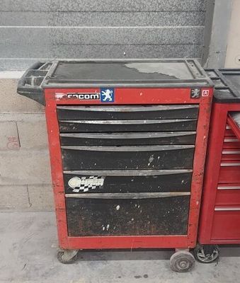 une boîte à outils rouge posée par terre à côté d'une autre boîte à outils rouge
