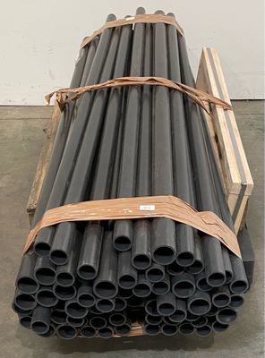 a stack of black pipes sitting on a pallet in a warehouse