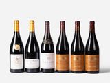 six bottles of red wine lined up in a row