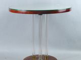 une table ronde en verre avec un piètement en bois et un plateau en verre transparent