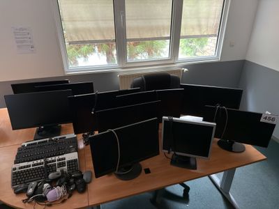 quatre écrans d'ordinateur posés sur un bureau, avec un clavier et une souris