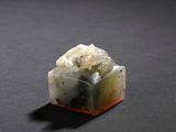 an image of a piece of green and white jade on a black surface