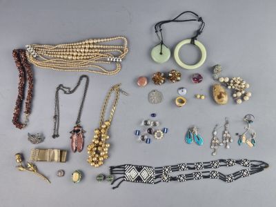 Plusieurs colliers, bracelets et autres bijoux sont disposés sur une table