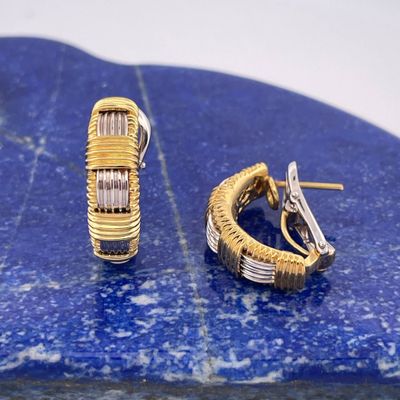 pair of gold and diamond hoop earrings on a blue marble slab