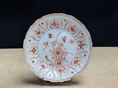 a white plate with orange flowers on it sitting on a table