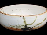 a white bowl with a brown rim on a black background