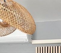 a rattan hanging from the ceiling above a radiator