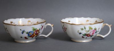 une paire de tasses en porcelaine ornées de motifs floraux sur fond gris