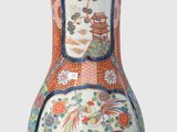 a vase that is sitting on a stand on a white surface