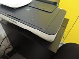a printer sitting on top of a desk next to a chair