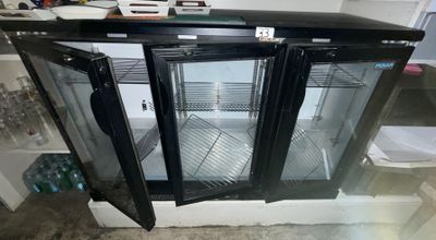 a refrigerator with two glass doors open in a kitchen