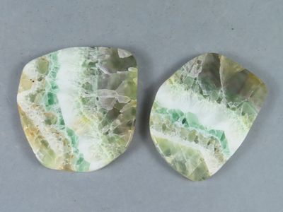 deux morceaux de marbre vert et blanc posés sur une surface grise