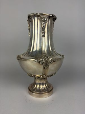 a silver vase that is sitting on a table