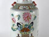 un vase orné d'un oiseau et de fleurs, posé sur une table