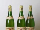 trois bouteilles de vin posées sur une table, l'une à côté de l'autre