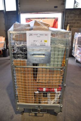 une cage métallique sur laquelle est accrochée une pancarte, dans un entrepôt
