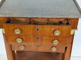 a small wooden table with a marble top on it