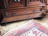 a large wooden cabinet with drawers and a rug on the floor