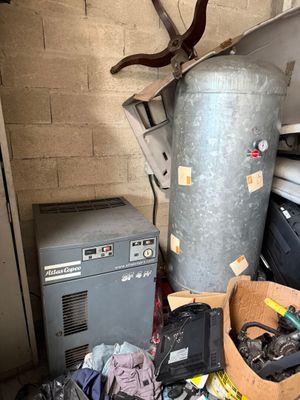 a pile of junk in a garage next to a water heater