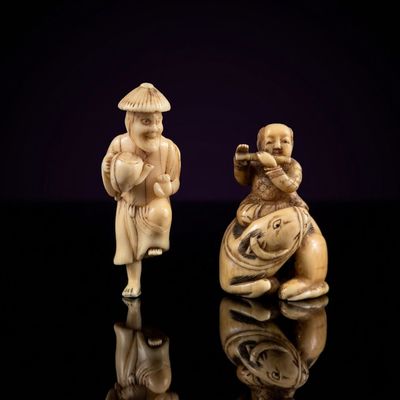 two carved figurines of a man and a woman playing a flute