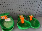 trois bols verts avec des anses orange posés sur une étagère