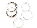 three rings and a beaded bracelet are sitting on a white surface