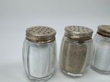 three salt shakers sitting next to each other on a table