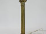 an antique brass table lamp with a white cord on the base
