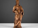 une statue en bois représentant un homme tenant un livre
