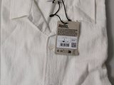 the shirt is white and has a tag on it