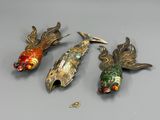 trois broches en forme de poisson posées sur une table