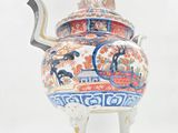 a tea pot with a handle on a stand