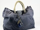 navy blue canvas tote bag with a rope handle and blue buttons