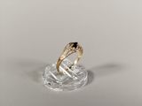 a close up of a gold ring with a black and white diamond