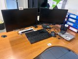 a desk with two monitors and a keyboard on it