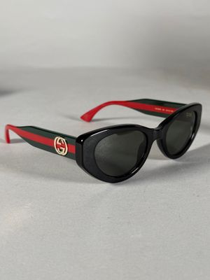 des lunettes de soleil noires avec des rayures rouges et vertes sur les branches