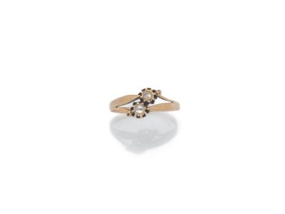 un gros plan d'une bague en or sertie d'une perle blanche