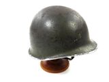 a metal helmet on a wooden stand on a white background