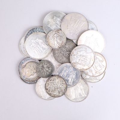 une pile de pièces d'argent posée sur une surface blanche