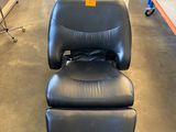 a black leather chair and ottoman in a store