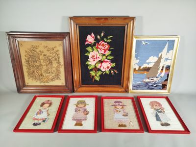 Trois photos encadrées représentant des enfants et un voilier sont posées sur une table