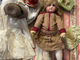 a doll laying on a bed next to a teddy bear