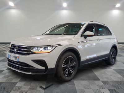 the white volkswagen suv is parked on a checkered tile floor